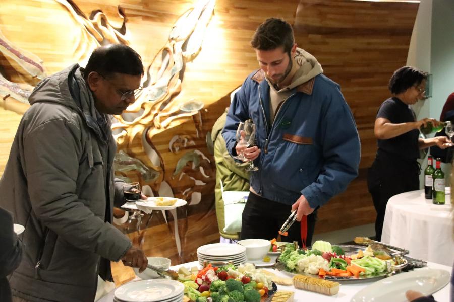 Two individuals enjoying refreshments at an indoor event.